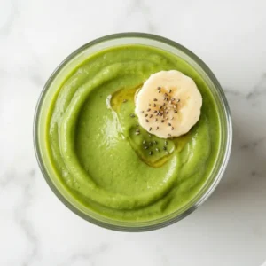 Overhead view of a delicious avocado smoothie in a clear glass ready to drink.